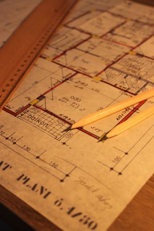 Ruler and pencils resting on an architectural floor plan sketch
